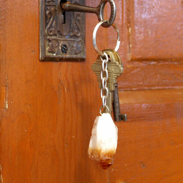Citrine Point Key Chain hanging out of lock on wooden door