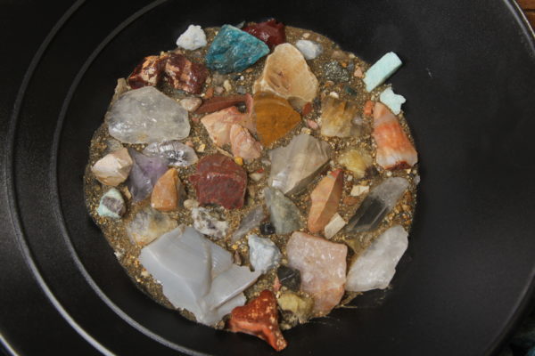 Close view of yellow bucket mining kit with gems, crystal ,pyrite, and arrowhead