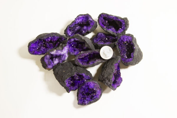 assorted small purple dyed geodes with quarter to show scale
