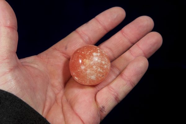 Orange Selenite Orbs in hand to show size