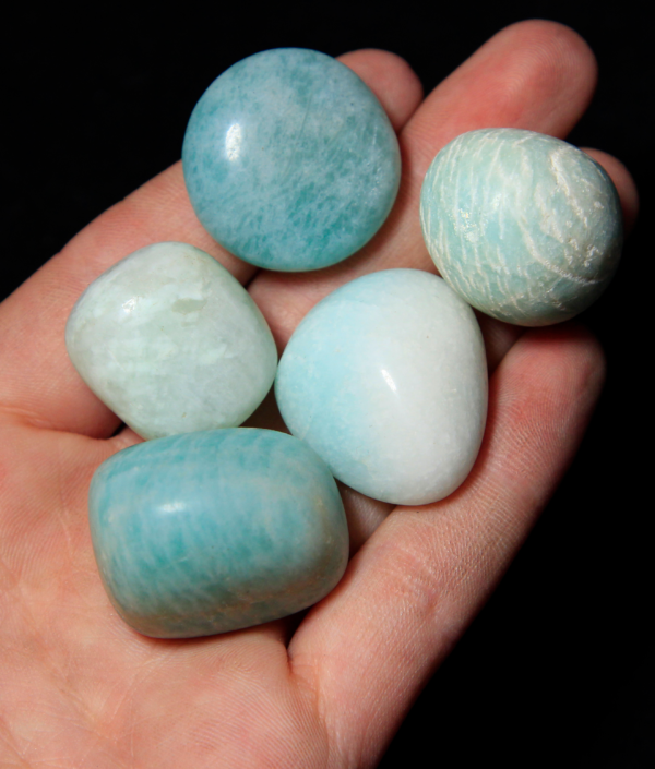 Pile of Small Tumbled Amazonite in hand for size