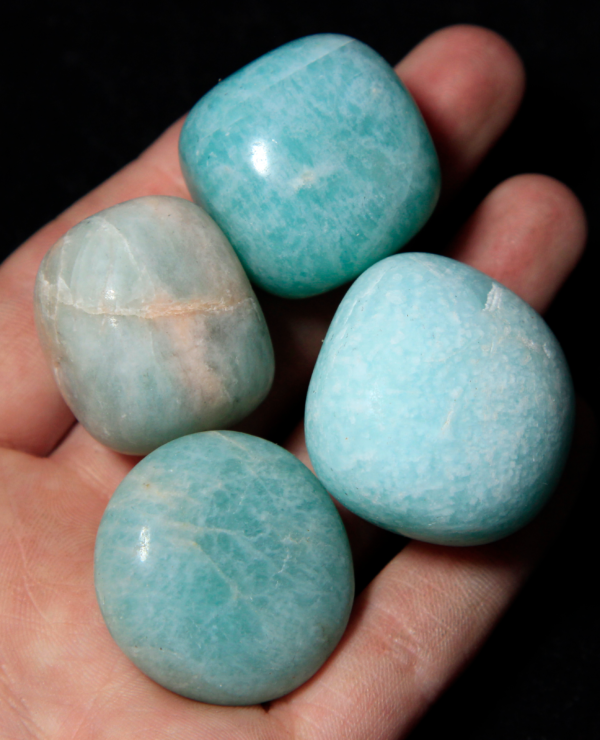 Pile of Medium Tumbled Amazonite in hand for size