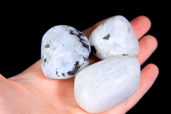 Large Tumbled Rainbow Moonstone Pieces between fingers for size