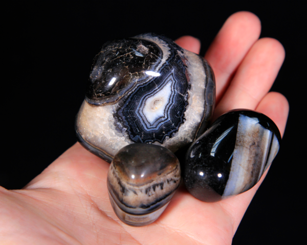 Large Tumbled Black Onyx Pieces in hand for size