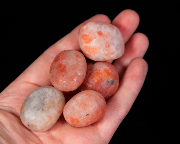 Small Tumbled Sunstone Pieces in hand for size