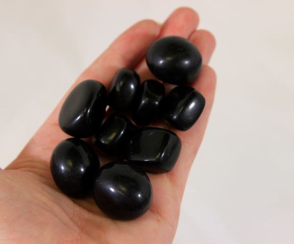 Small Black Obsidian Stones in hand for size comparison
