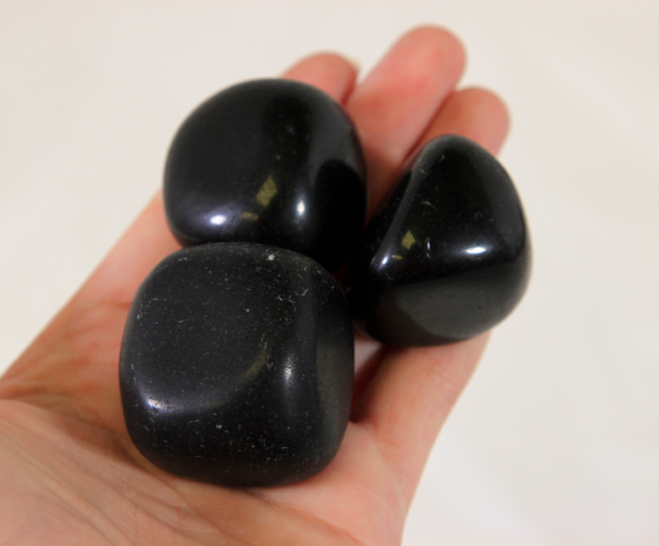 Large Black Obsidian Stones in hand for size comparison