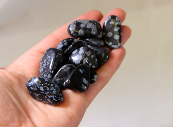 Several Black Snowflake Obsidian Stones in Palm for size comparison