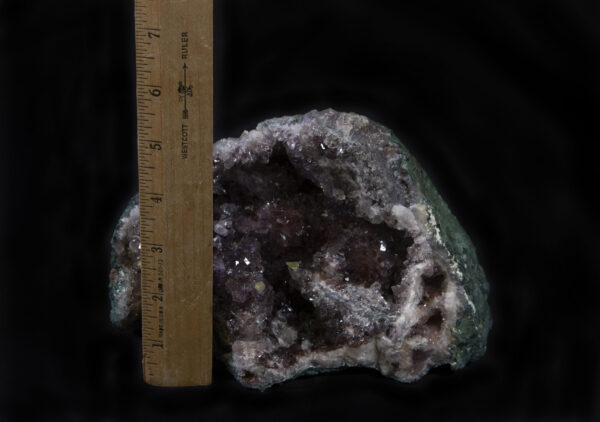 Smokey-colored Amethyst Geode with green rock next to ruler