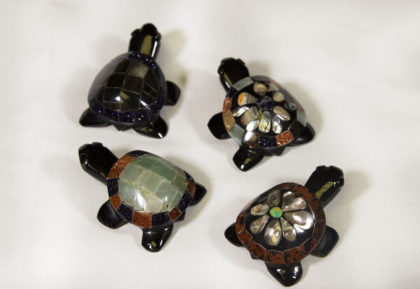 Four small black decorative turtles with assorted colored shells