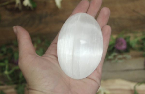 Selenite Polished Palm stone in hand for size