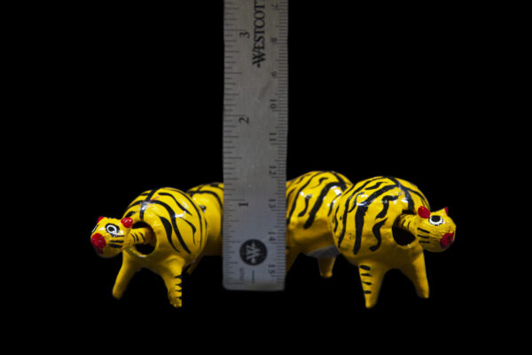 Yellow Looseneck Tiger Figurines next to ruler for size comparison