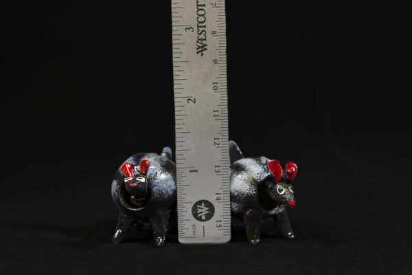 Two LooseNeck Skunks Figurines next to ruler for size comparison