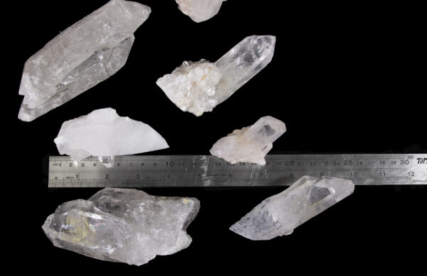 quartz points in a pile with ruler to show size