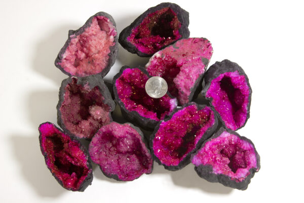 assorted large pink dyed geodes with quarter to show scale