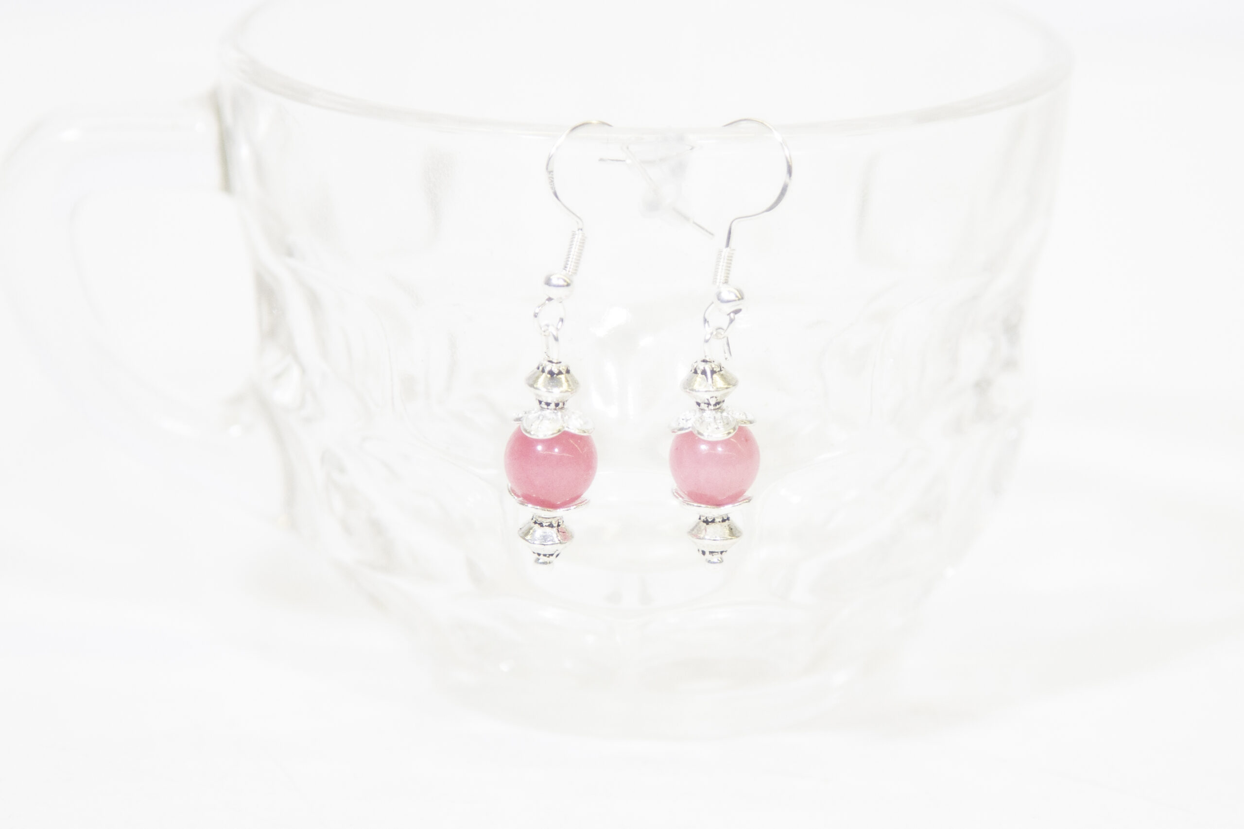 Rose Quartz Earrings Hanging on side of glass cup