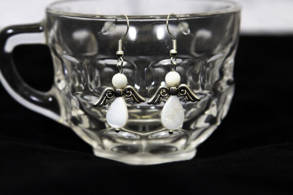 Mother of Pearl Angel Earrings hanging on a glass cup