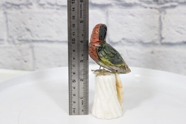 Green and Red Hand Carved Parrot on Stand Natural Gemstone next to ruler for size comparison